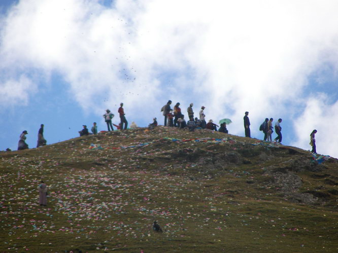 Festival goers throwing prayer flags at Drak Yerpa tsechu festival. 